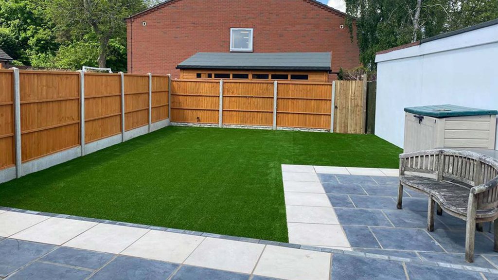 Back garden fencing renovation work with a patio and new-lawn.